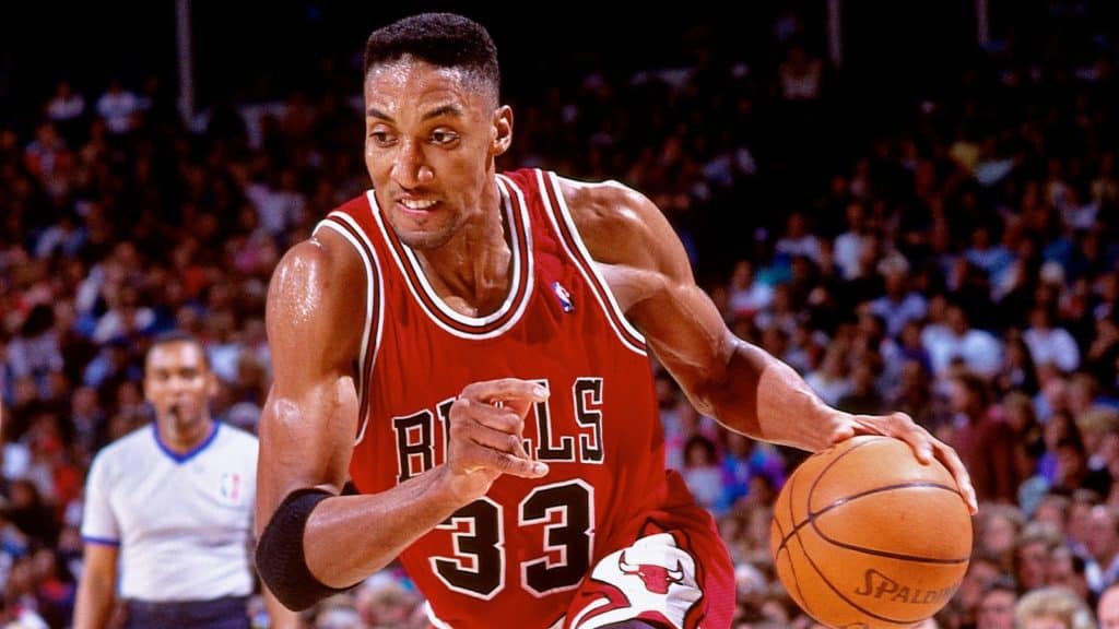 Scottie Pippen aggressively driving the ball to his left.