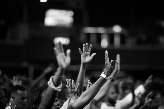 grayscale photography of people raising hands 2014775