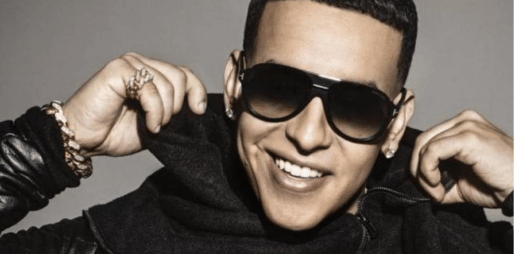 Daddy Yankee posing with sunglasses on and rings looking rich